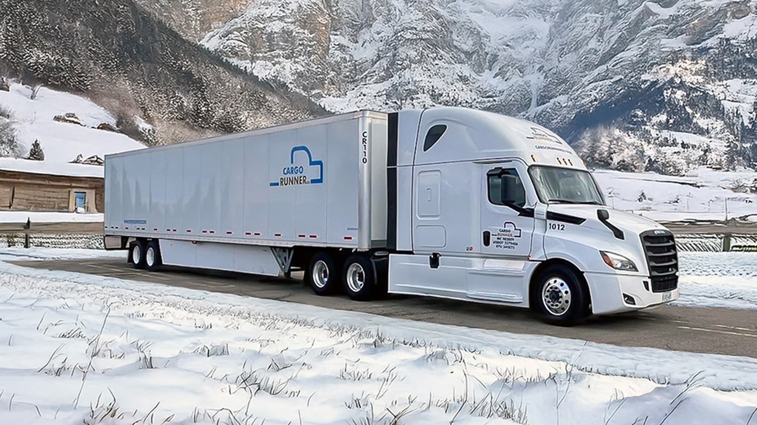 Cargo Runner truck driving through a snowy mountain route